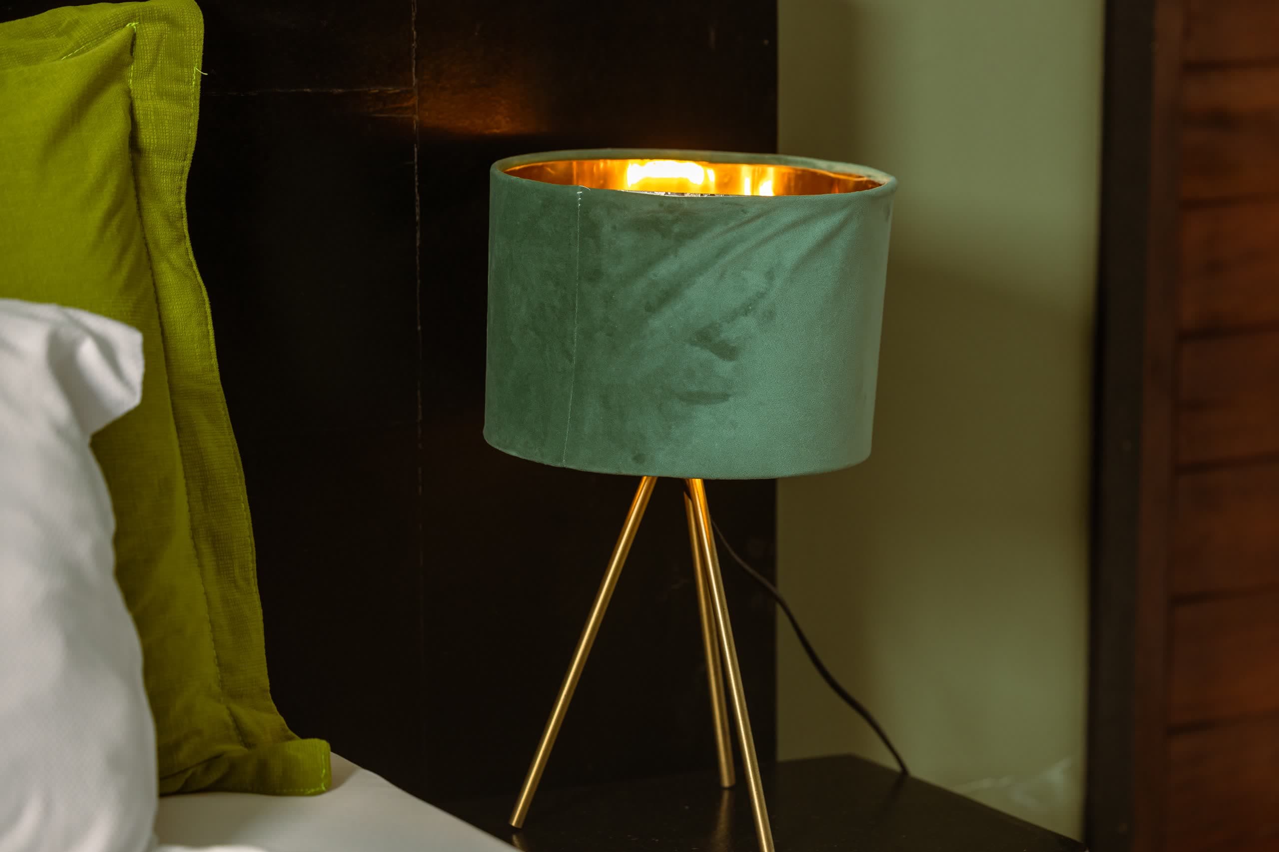 Lampe de chevet verte à trépied doré, détail de chambre