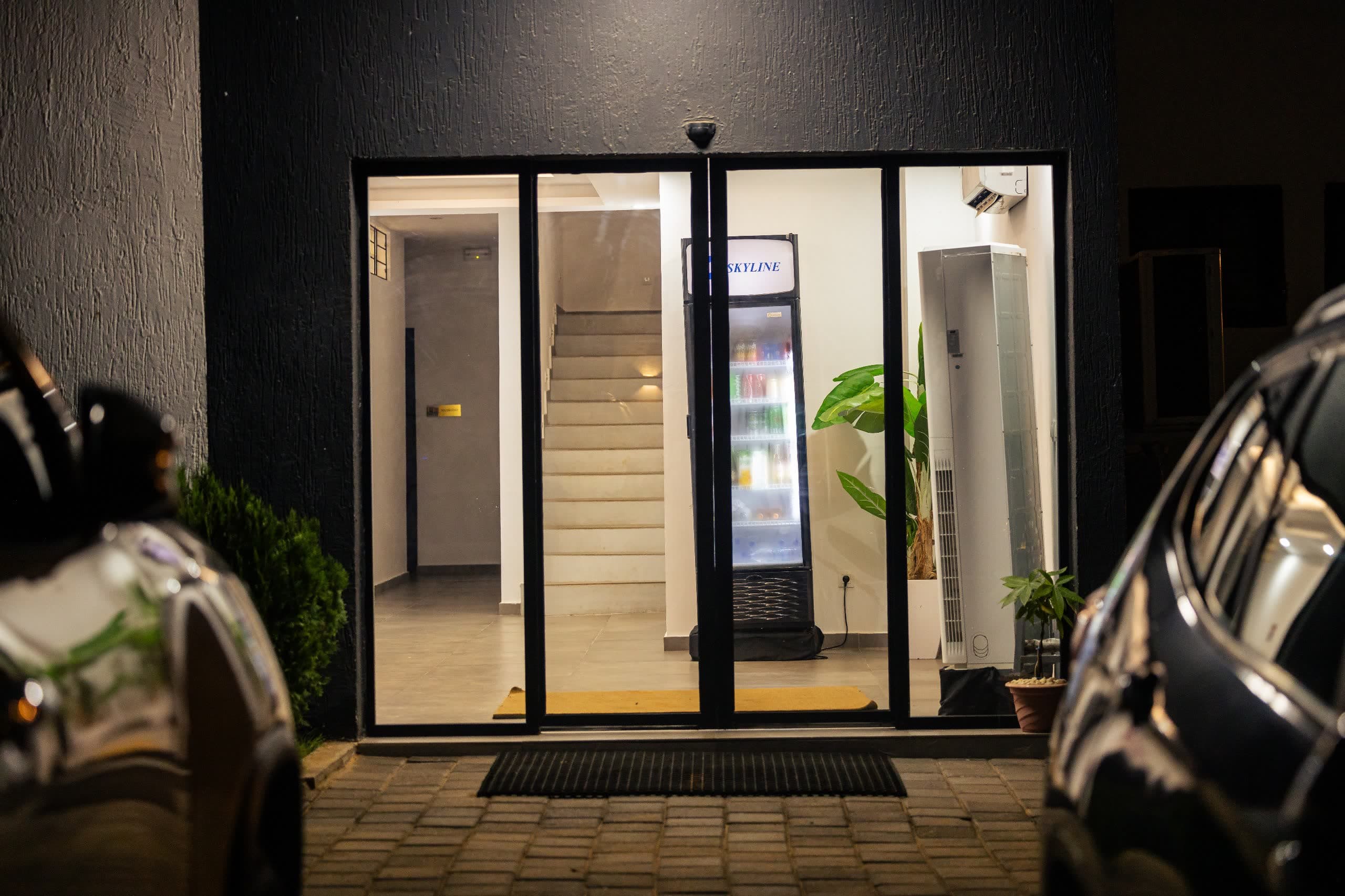 Entrée vitrée de NH Le Rêve éclairée la nuit avec hall et plantes