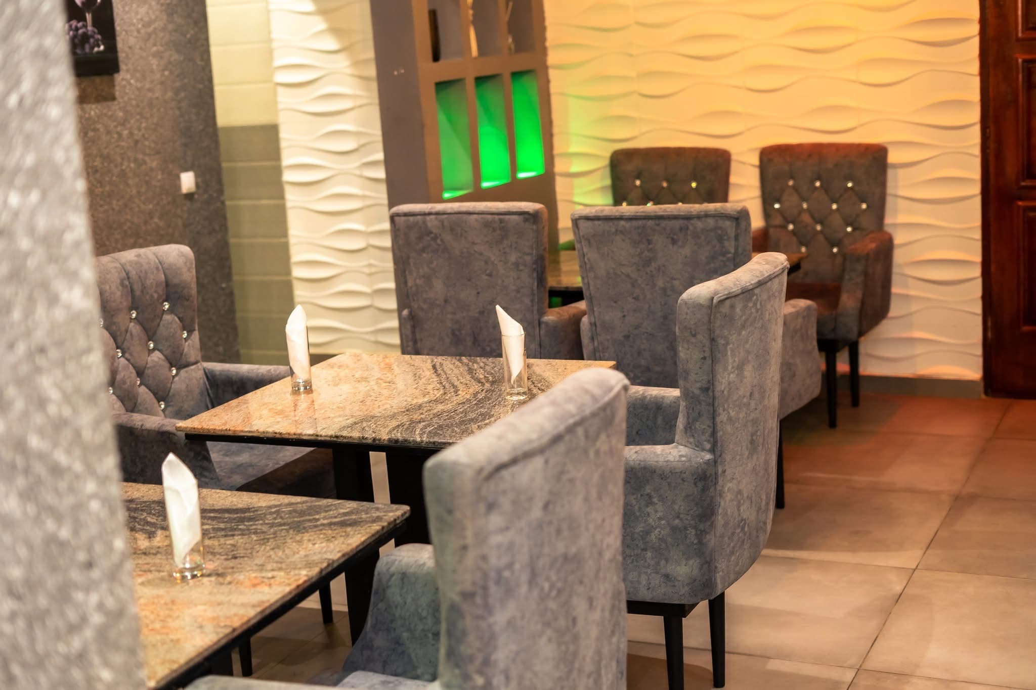 Restaurant avec fauteuils capitonnés et tables en marbre
