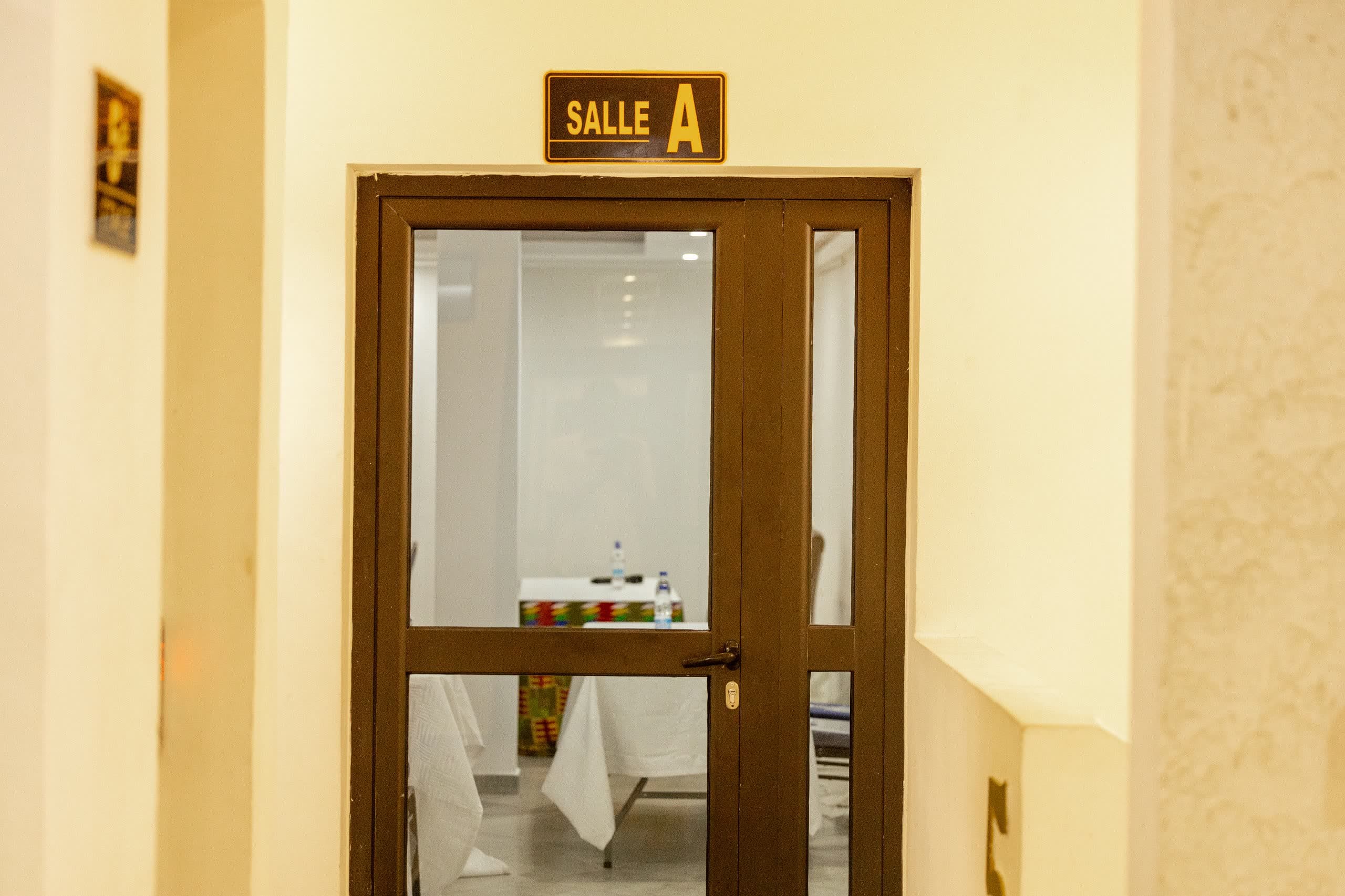 Porte vitrée de la Salle A et sa plaque de signalétique dorée